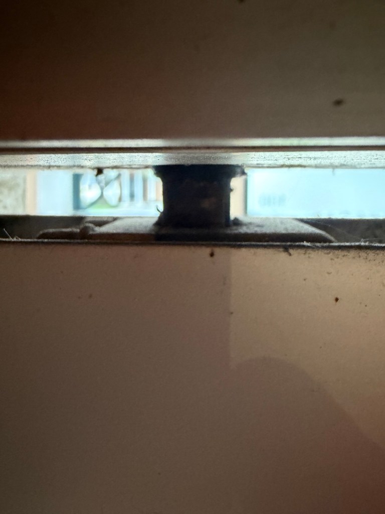 Close-up of the gap and hardware at the top of a door.